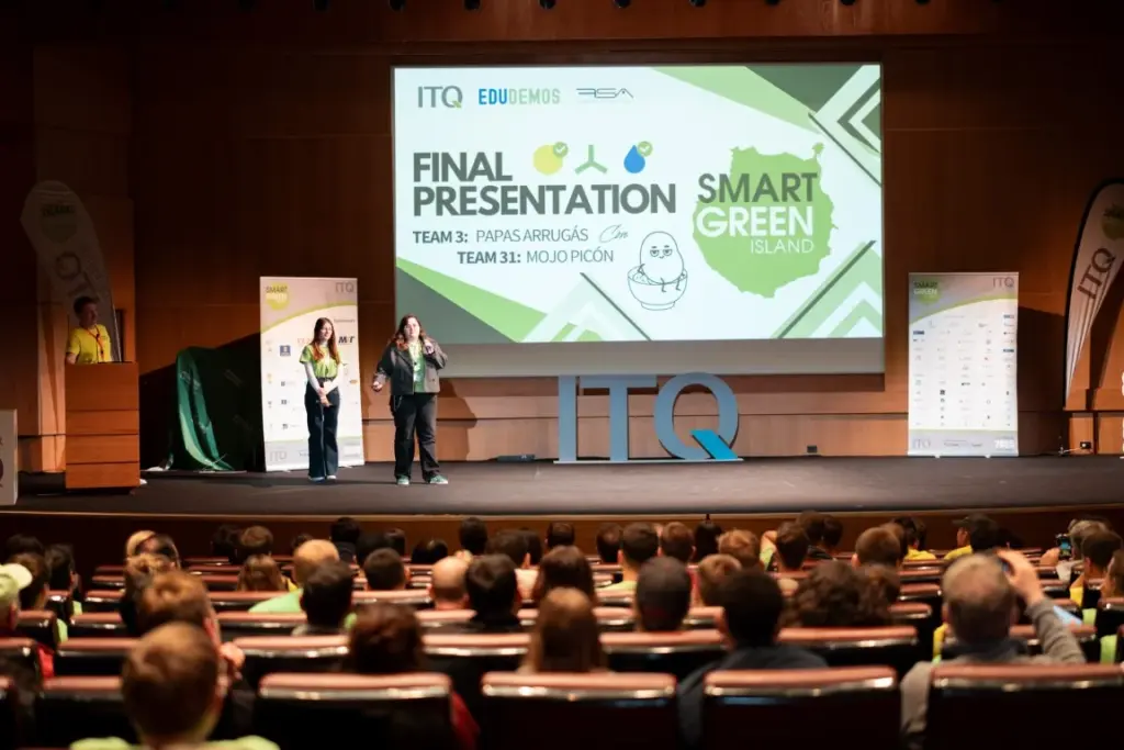 Bei einer „Smart Green Island“-Veranstaltung stehen zwei Referenten auf der Bühne und halten vor dem Publikum, das in einem Auditorium Platz genommen hat, ihren abschließenden Vortrag.